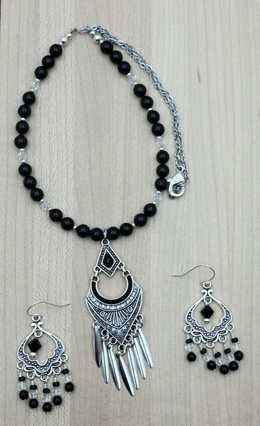 An intricate & fancy lead-free pewter pendant features a black stone & pewter blade fringe.  Also pewter & crystal chandelier earrings