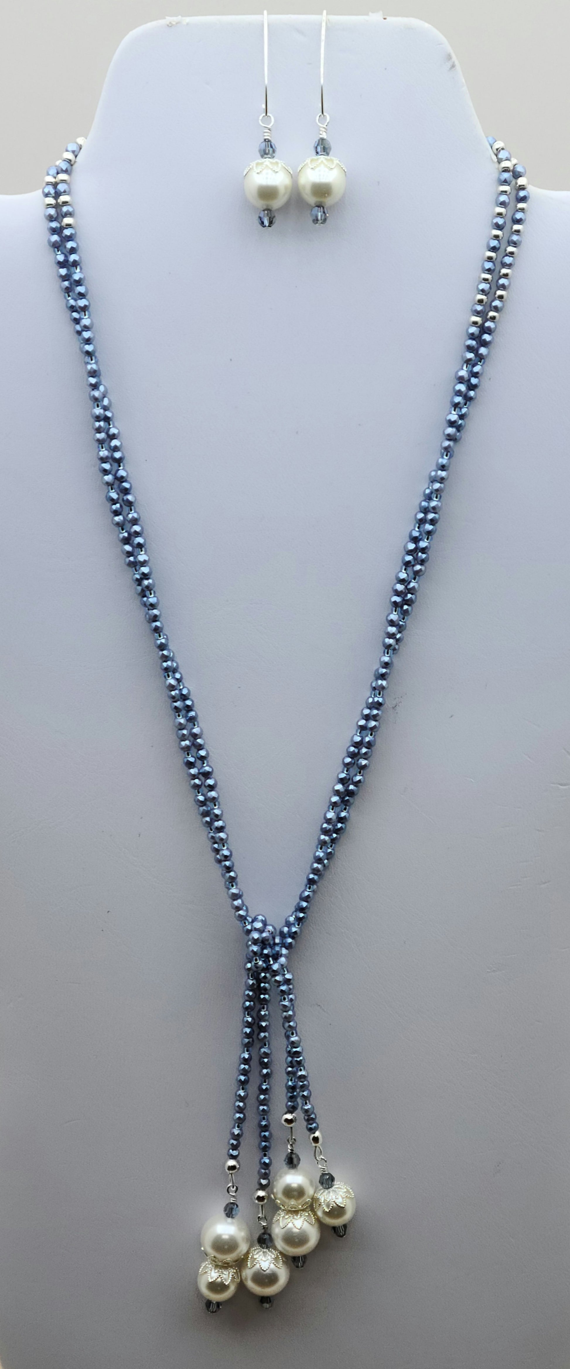 You'll turn heads with this elegant & sparkling lariat of tiny sky blue shell pearls, large white shell pearls, & sapphire crystals with coordinating long fish hook earrings