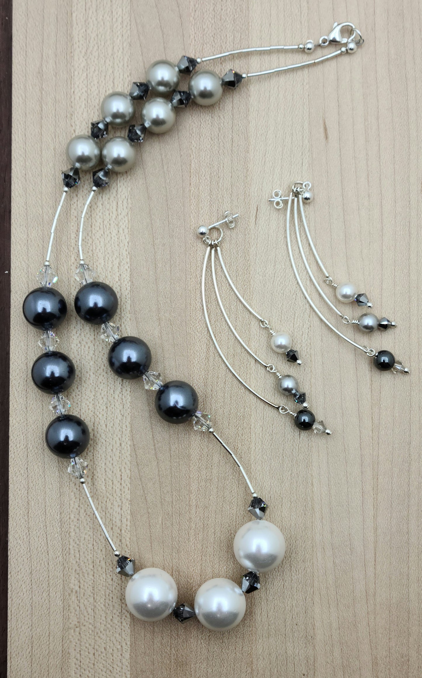 Large light silver, dark silver, and white shell pearls shine alongside liquid silver accents and sparkling crystals in this elegant matching set. Crystal pearl, crystal, hematite, & sterling silver earrings - curved bars on ball post