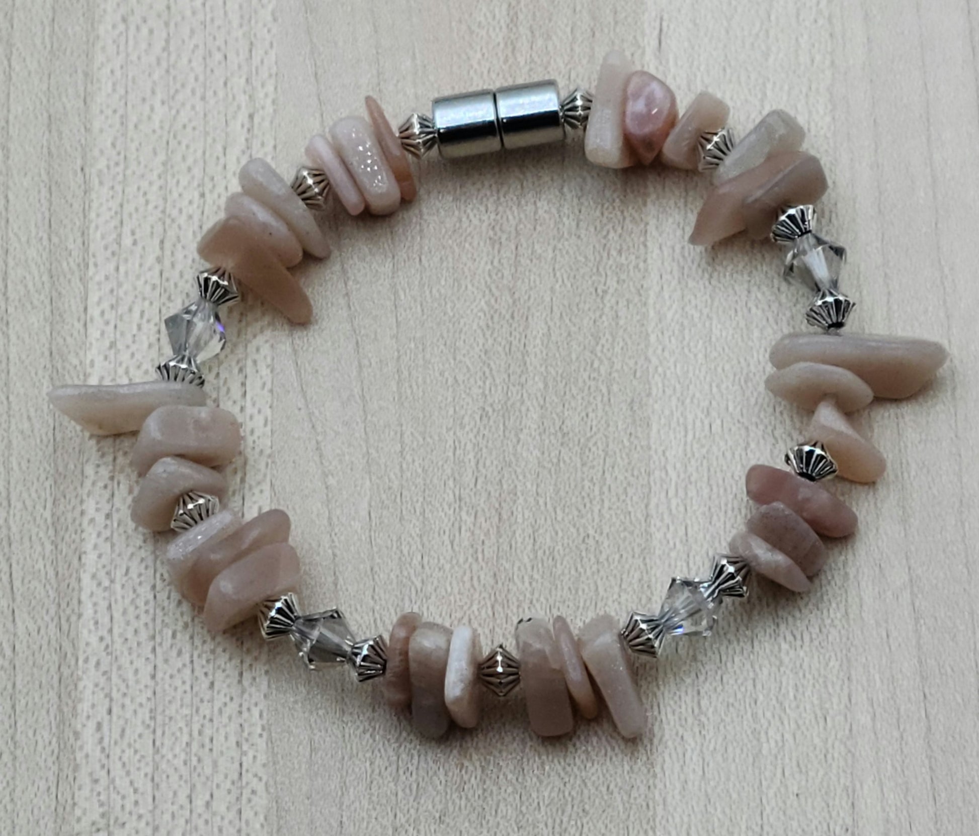 The soft look of peach moonstone nuggets is enhanced with crystals* and pewter beads to create a lovely bracelet. Has magnet closure.
