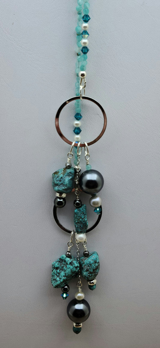 Lariat style necklace of shell pearls, fw pearls, hematite, crystals, turquoise, & amazonite. 