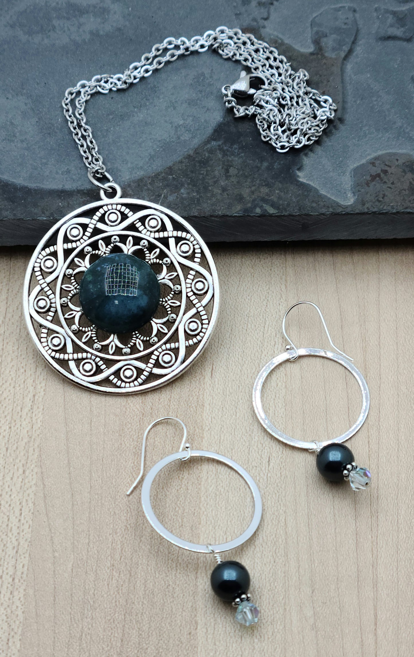 This filigree pewter pendant hosts a lovely blue/green jasper cabochon. The earrings are rhodium plated, with crystal pearl, crystal dangles, & sterling silver fish hook ear wires.