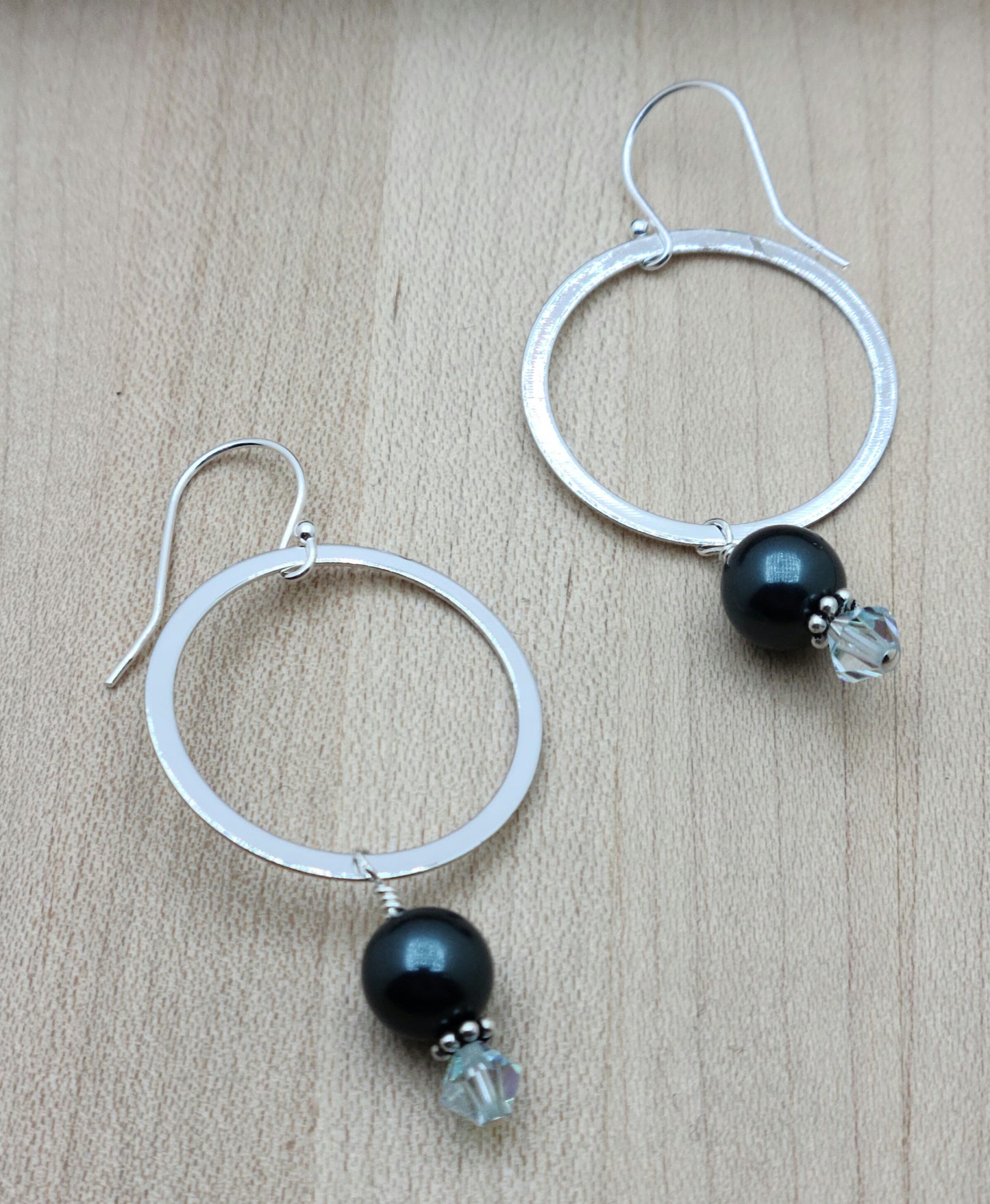  The earrings are rhodium plated, with blue/green crystal pearls, crystal dangles, & sterling silver fish hook ear wires.