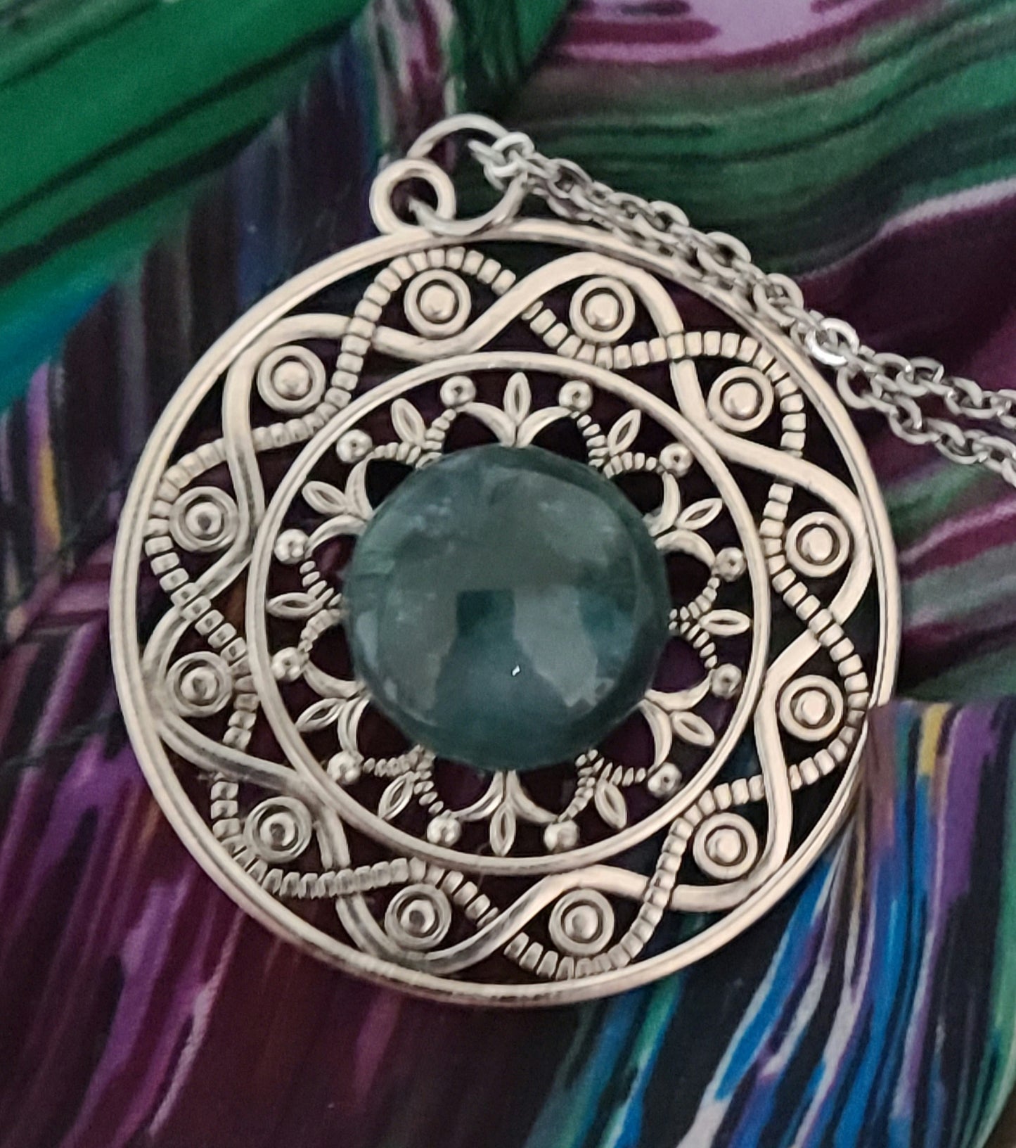 This filigree pewter pendant hosts a lovely blue/green jasper cabochon.