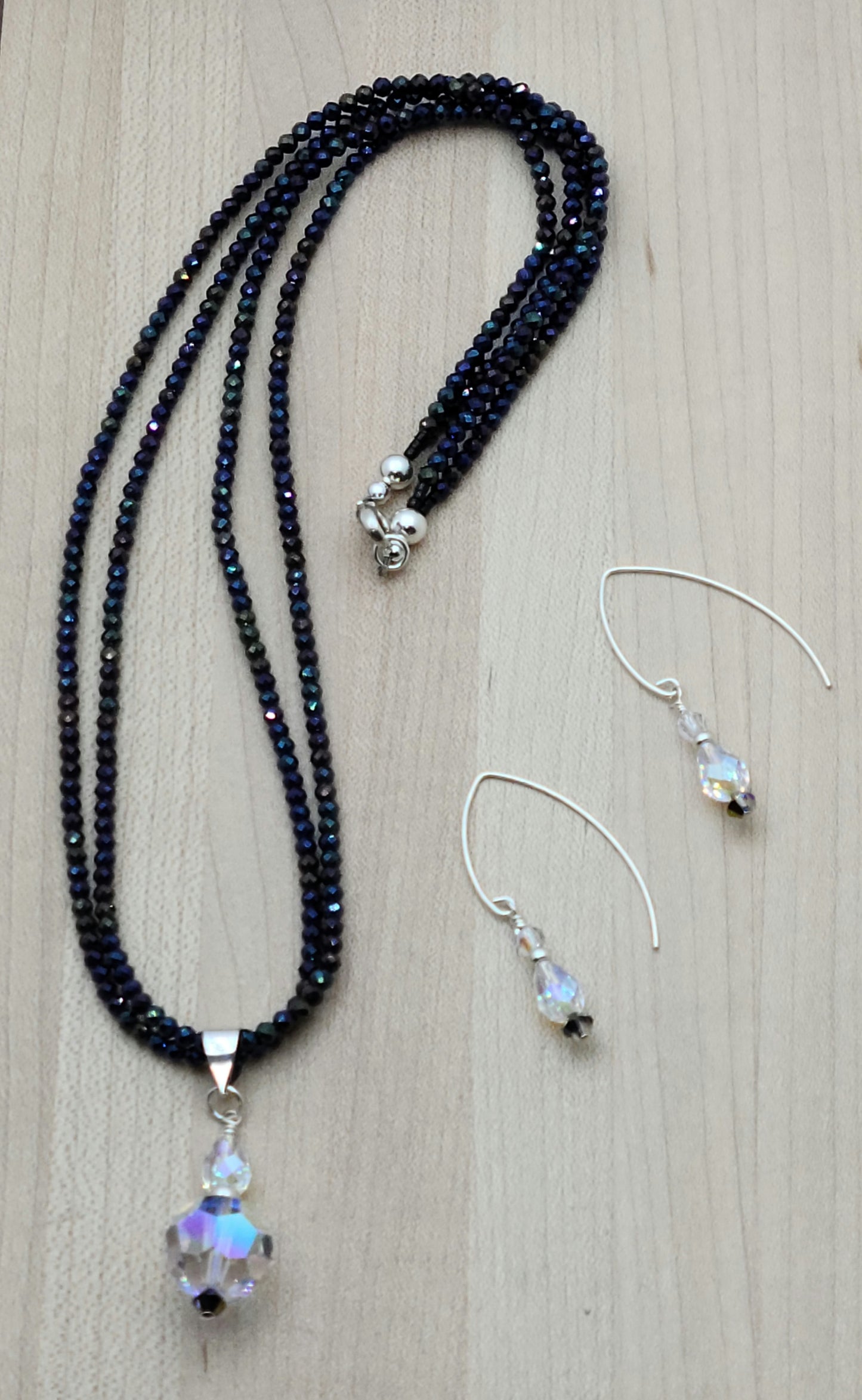 You'll be drawn to the shimmery aurora borealis coating of these tiny black spinel stones and that shimmer continues in the aurora borealis coating of the crystal pendant.