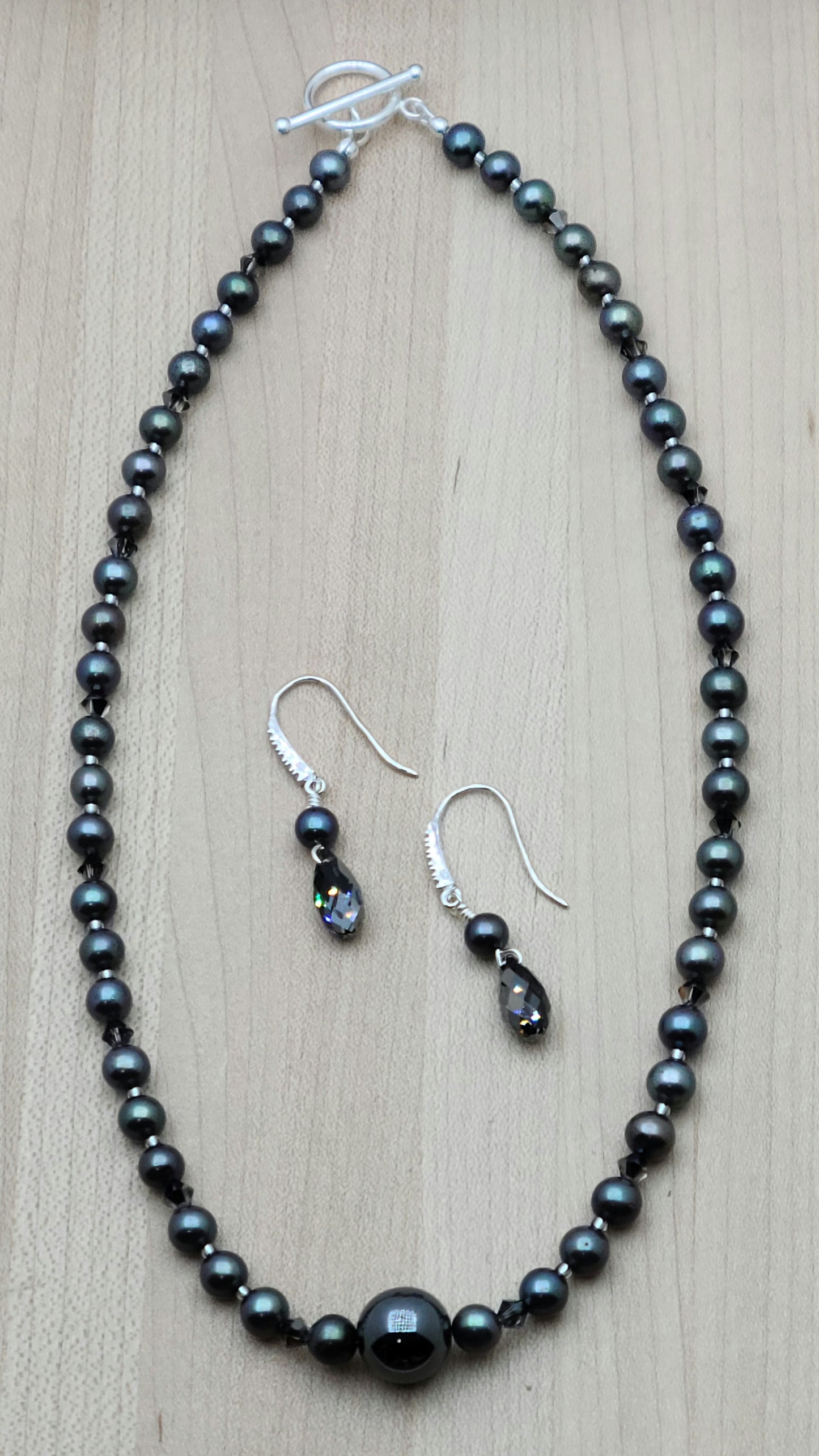 With a dark bluish grey cast, these black freshwater pearls look great with the single, large shiny grey hematite statement bead and silver night crystals!
