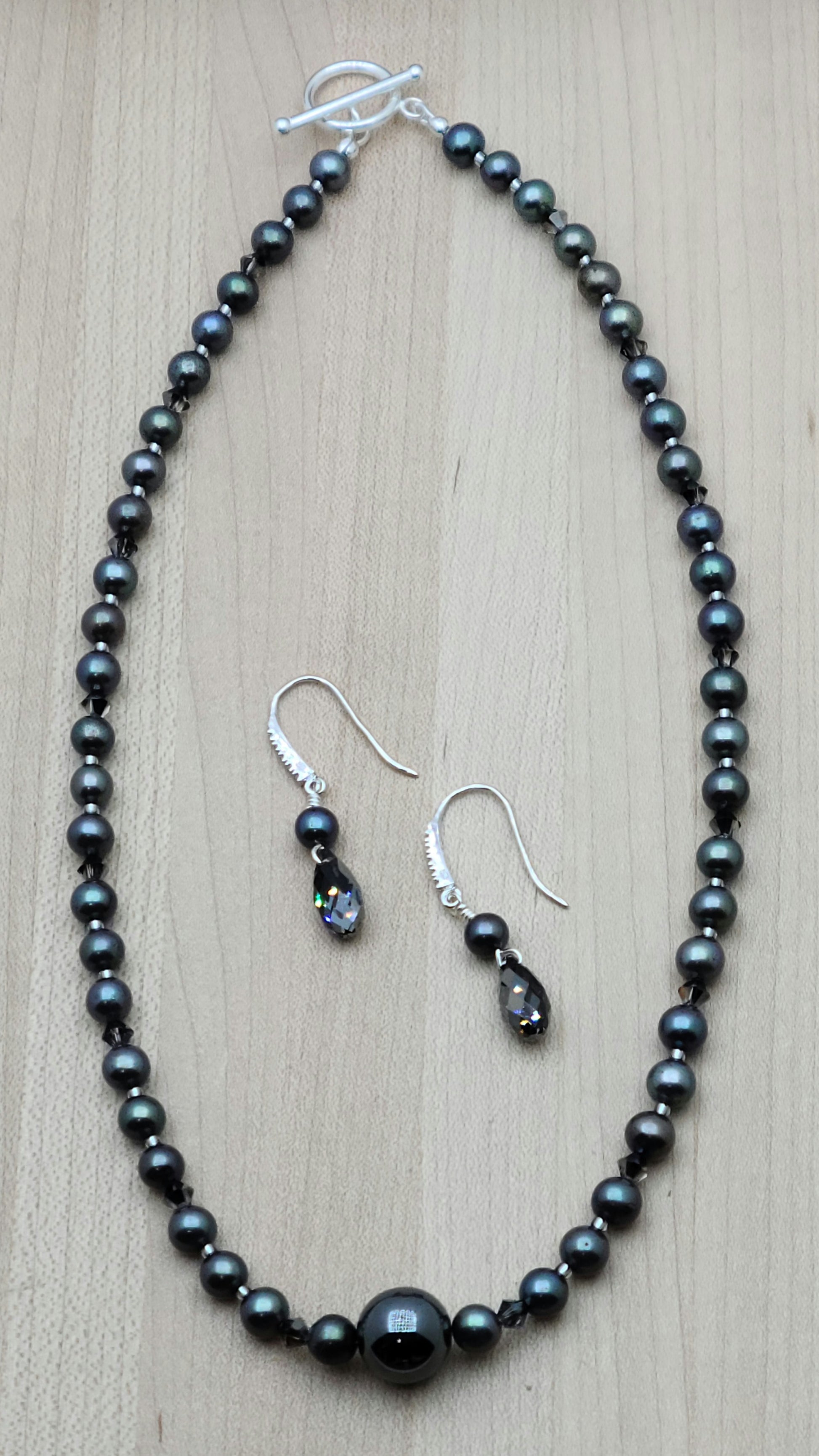 With a dark bluish grey cast, these black freshwater pearls look great with the single, large shiny grey hematite statement bead and silver night crystals!