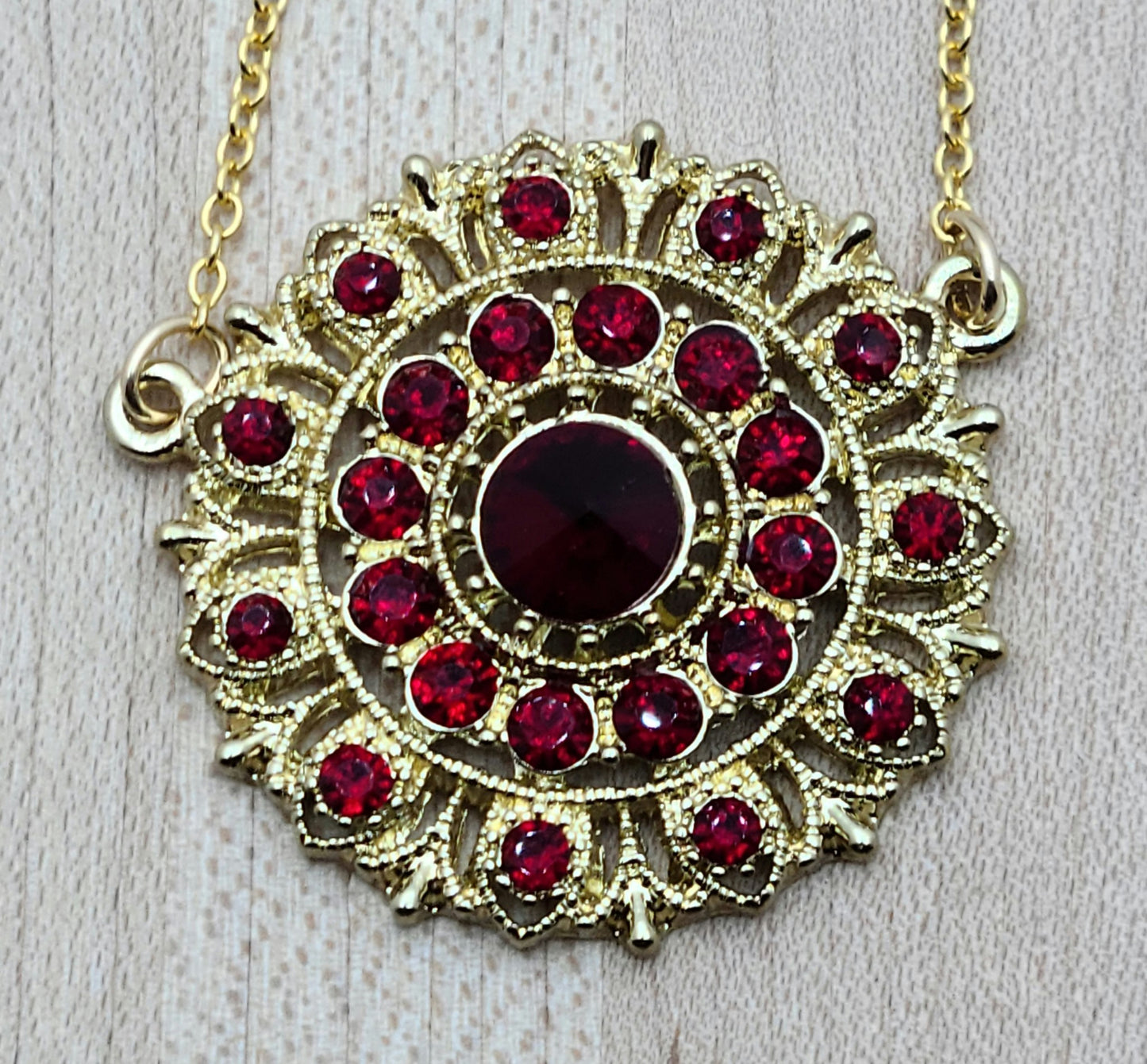 I found a gorgeous gold vintage scarlet crystal* encrusted medallion, added chain and earrings, and voila - a very striking set!