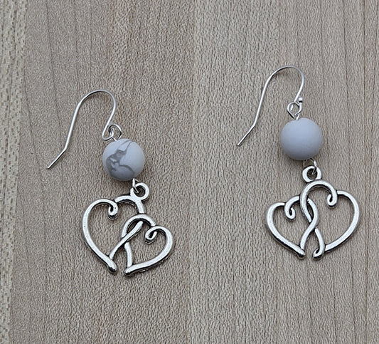 These lead-free pewter entwined heart earrings are simple, adorable, and extremely lightweight. A fun look without the weight! The hearts hang from white howlite beads for a neutral color profile.