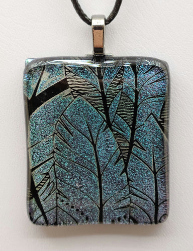 Unleash your inner boho with the Celadon Feathers Fused Glass Pendant.