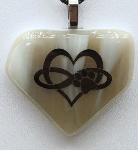 This Paw on Sand Fused Glass Pendant is the perfect way to symbolize the infinite love we have for our pets. 