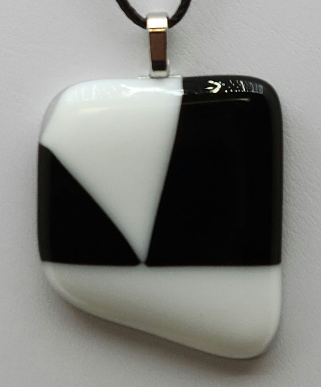 Experience the perfect combination of classic style and bold design with our White V on Black Fused Glass Pendant. 