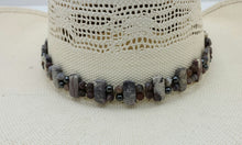 This hatband combines porcelain jasper, botswana agate, hematite, & leather! Adjustable by a leather slider knot.