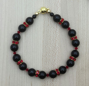 The bold colors of black & red are celebrated in this bracelet of black crystal pearls & bright red crystal rondelles with magnetic clasp