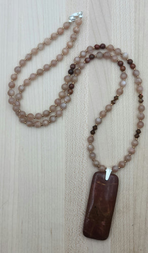 In this necklace a deeply rust red Red Creek jasper pendant is suspended from complimentary pale peach moonstone beads & accented by dark topaz crystals*.